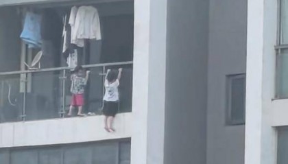 吓人!幼童爬到13层阳台外悬空玩“引体向上”,街道办:已告诫家长加强看护